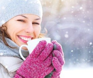 Woman winter gloves hat scarf hot coffee mug smiling outdoor snow